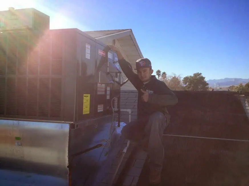 HVAC technician performing AC Tune-Up on a rooftop unit in Calabasas